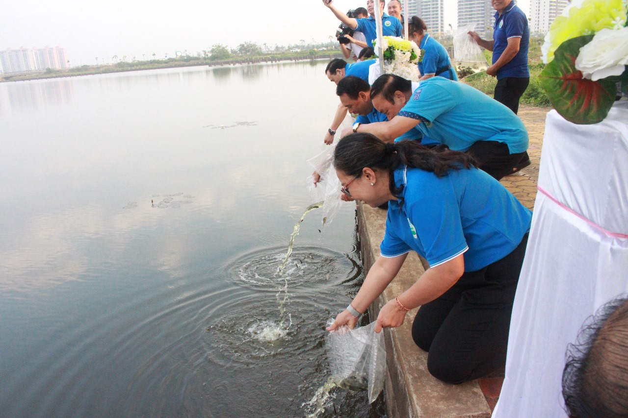 People releasing fish from plastic bags into the river