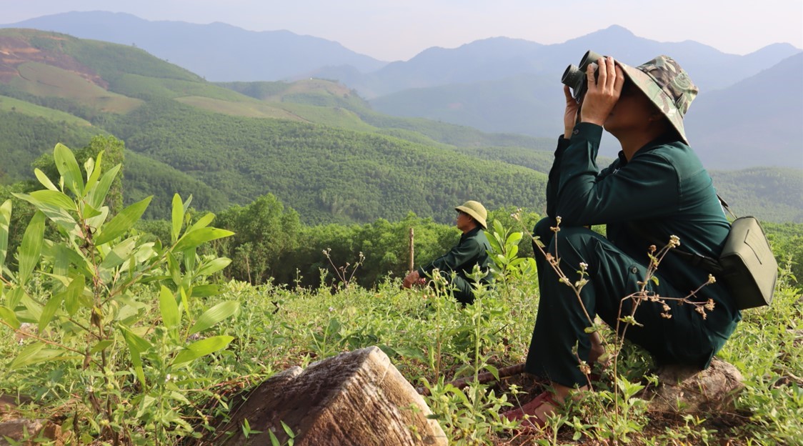 Man looking through binoculars in a field