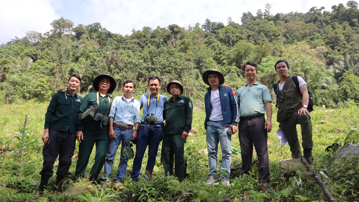 8 men standing in a field looking at the camera