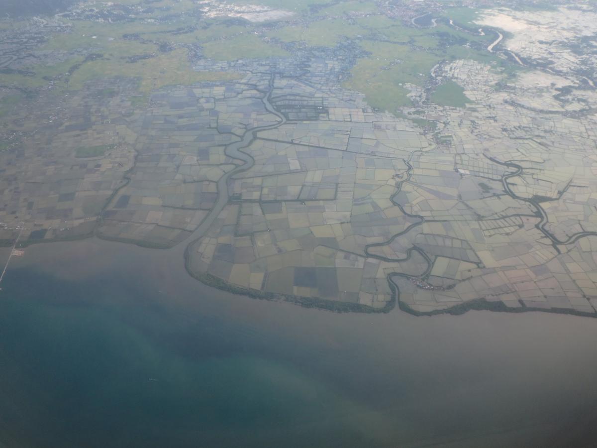 Aerial view of thin line of mangroves protecting the coastlines of Sulawesi Island, Indonesia. 