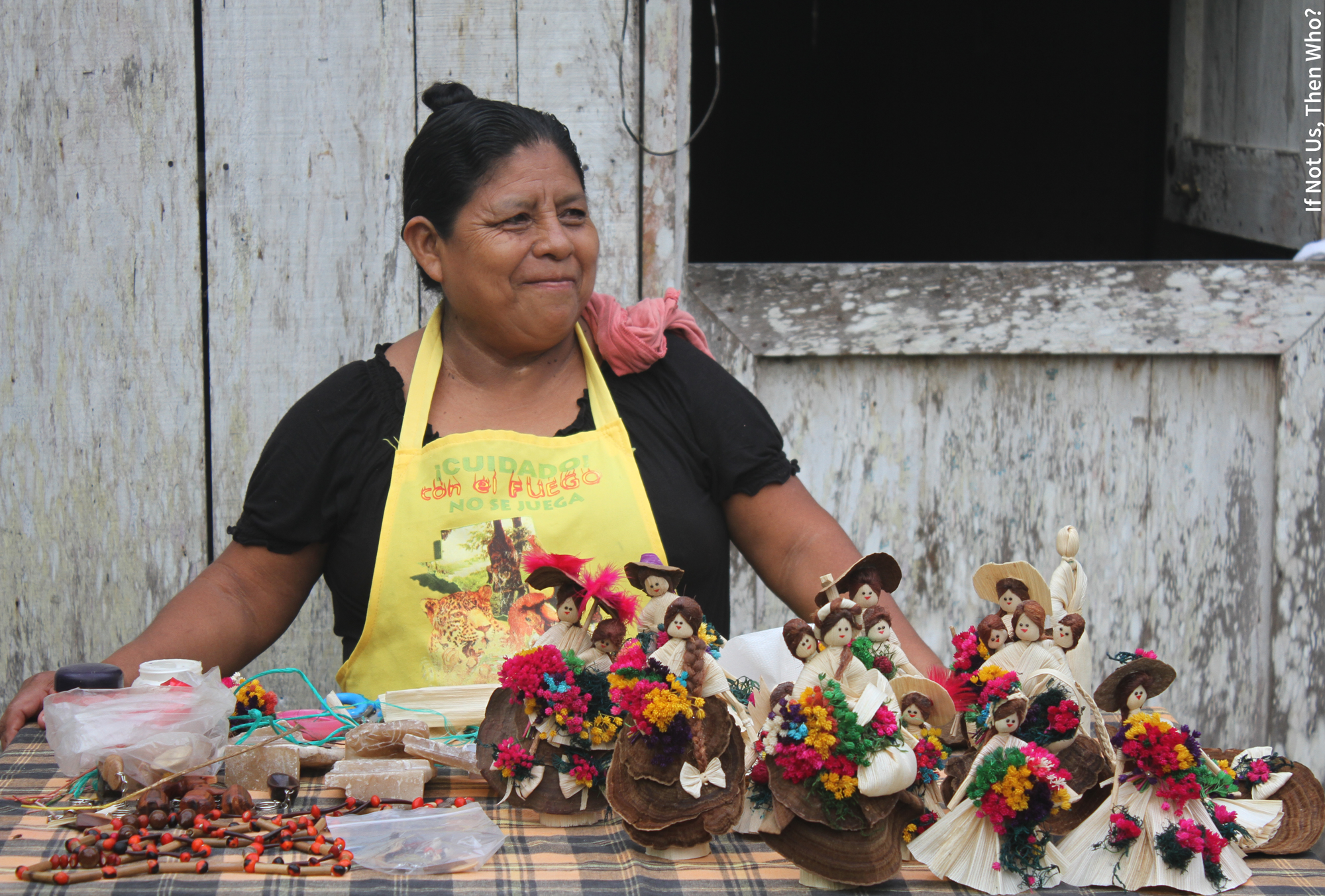 smiling women with apron selling little dolls