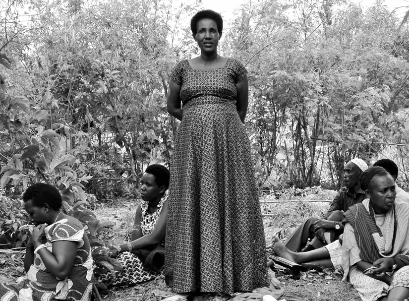 woman standing in middle with others sitting on ground