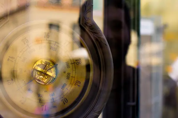 old wooden barometer behind glass, reflection on right